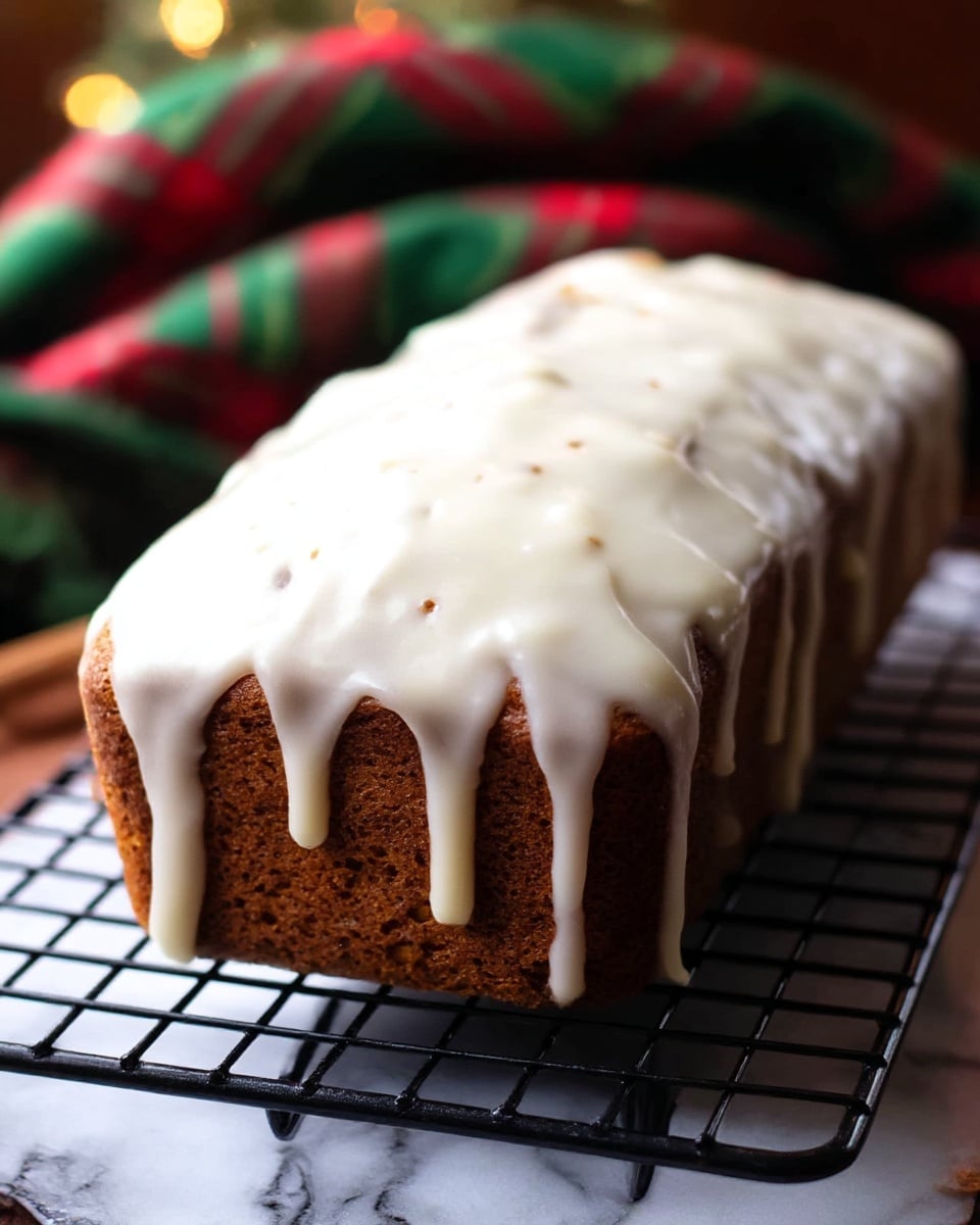 A rectangular brown loaf cake sits on a black cooling rack above a white marbled surface. The cake is covered in a thick, white icing glaze that drips over the sides unevenly, creating smooth, creamy drips. The glaze shows small cracks and tiny brown spots where the cake peeks through, giving it a homemade look. In the background, there is a soft, blurred green and red plaid cloth, adding a festive touch. The warm lighting highlights the moist texture of the cake and the glossy, slightly shiny icing. Photo taken with an iphone --ar 4:5 --v 7