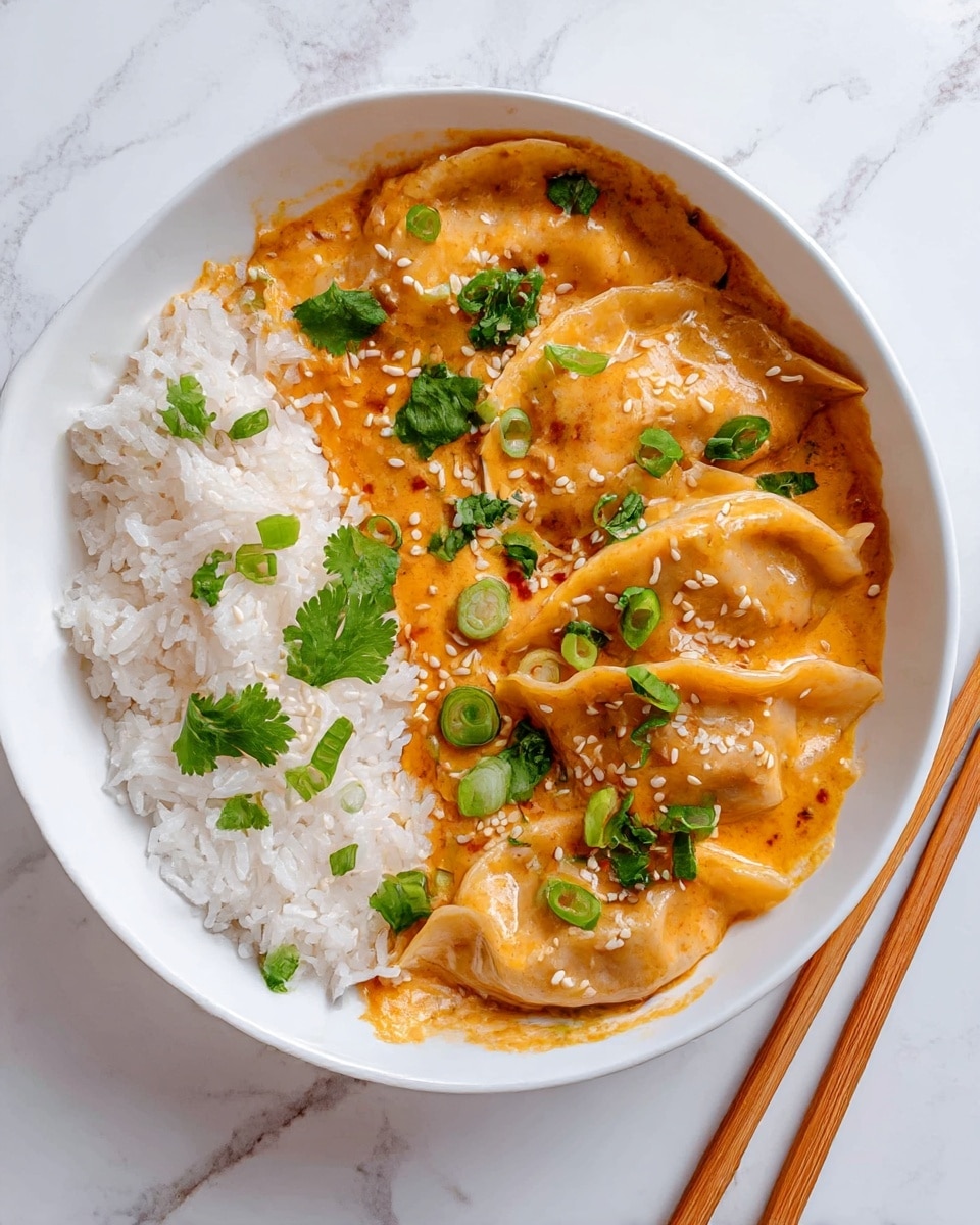 A white round bowl contains a layered dish with white steamed rice piled on one side, fluffy and soft in texture, partially soaked by a creamy orange sauce. Surrounding the rice are five golden-brown dumplings coated in the same sauce, showing slight crisp edges and folds, garnished with bright green chopped scallions, sprigs of fresh cilantro, and scattered white sesame seeds. The bowl is placed on a white marbled surface with wooden chopsticks laid beside it, adding a simple touch to the clean presentation. Photo taken with an iphone --ar 4:5 --v 7