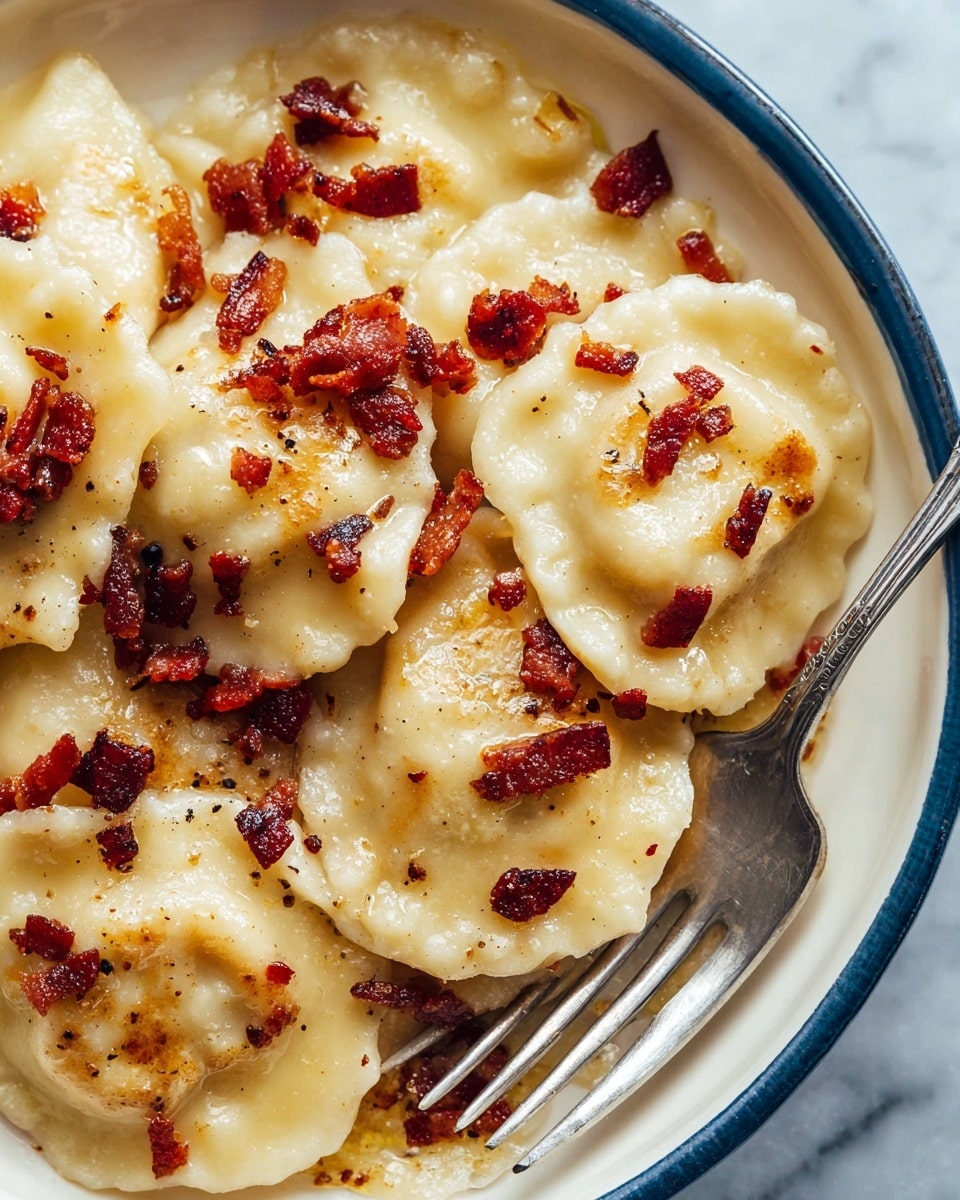 This close-up image shows a white bowl filled with several round ravioli pieces, each with a slightly uneven, soft texture and a light golden color with slight browning spots. The ravioli are topped with small, crispy crumbles of dark reddish-brown bacon scattered evenly across the dish. The edges of the ravioli have a mildly ruffled look, and a silver fork rests on the right side inside the bowl. The whole scene is set against a white marbled texture background. photo taken with an iphone --ar 4:5 --v 7
