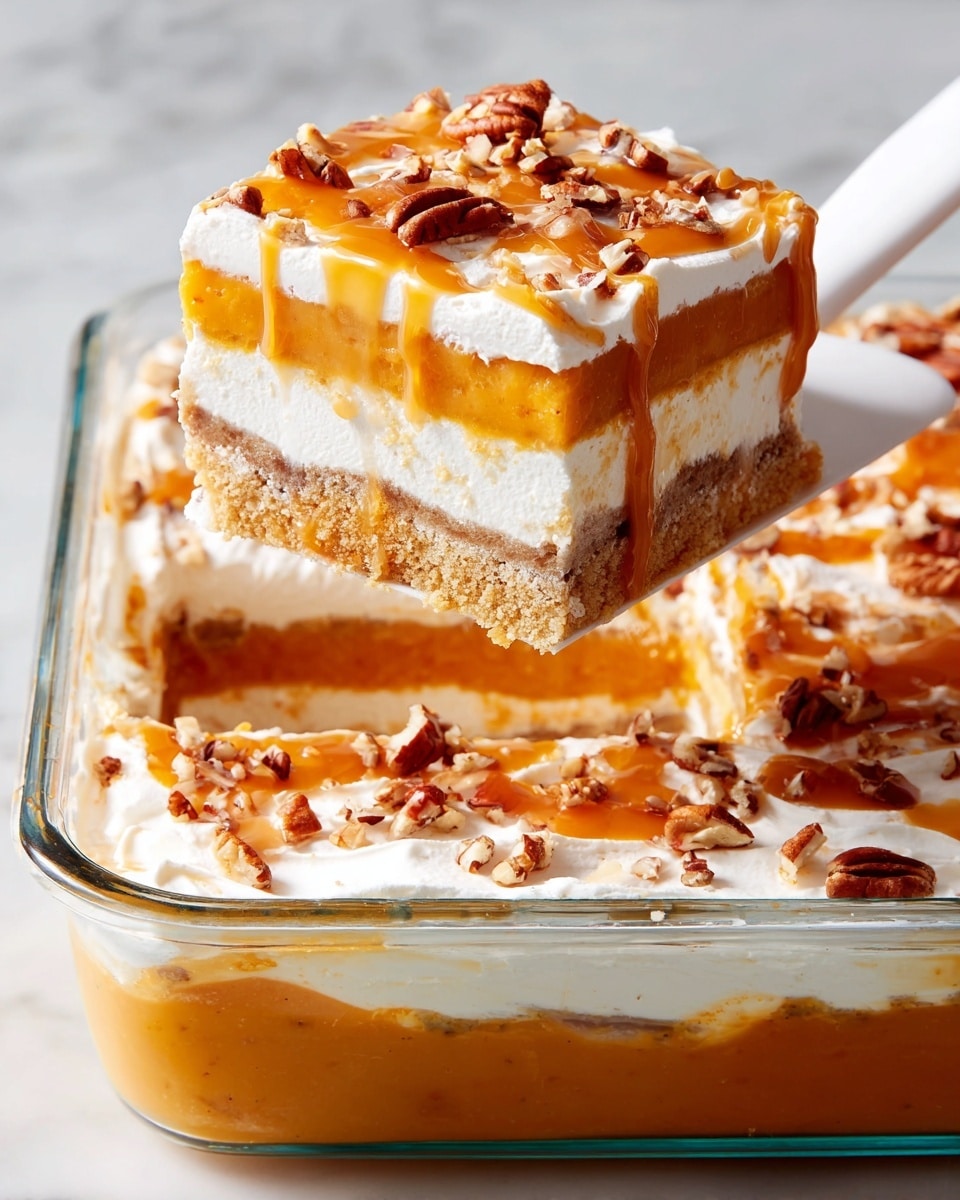 A glass dish filled with a layered dessert that has four distinct layers: at the bottom is a thick, smooth orange layer, followed by a thin light brown crumbly layer, then a middle white creamy layer, topped again by the light brown crumbly layer and a final thick white whipped cream layer. The top is drizzled with amber caramel sauce and sprinkled with chopped pecans. A square piece is being lifted out with a white spatula showing the clear separation of each layer against a white marbled background. photo taken with an iphone --ar 4:5 --v 7