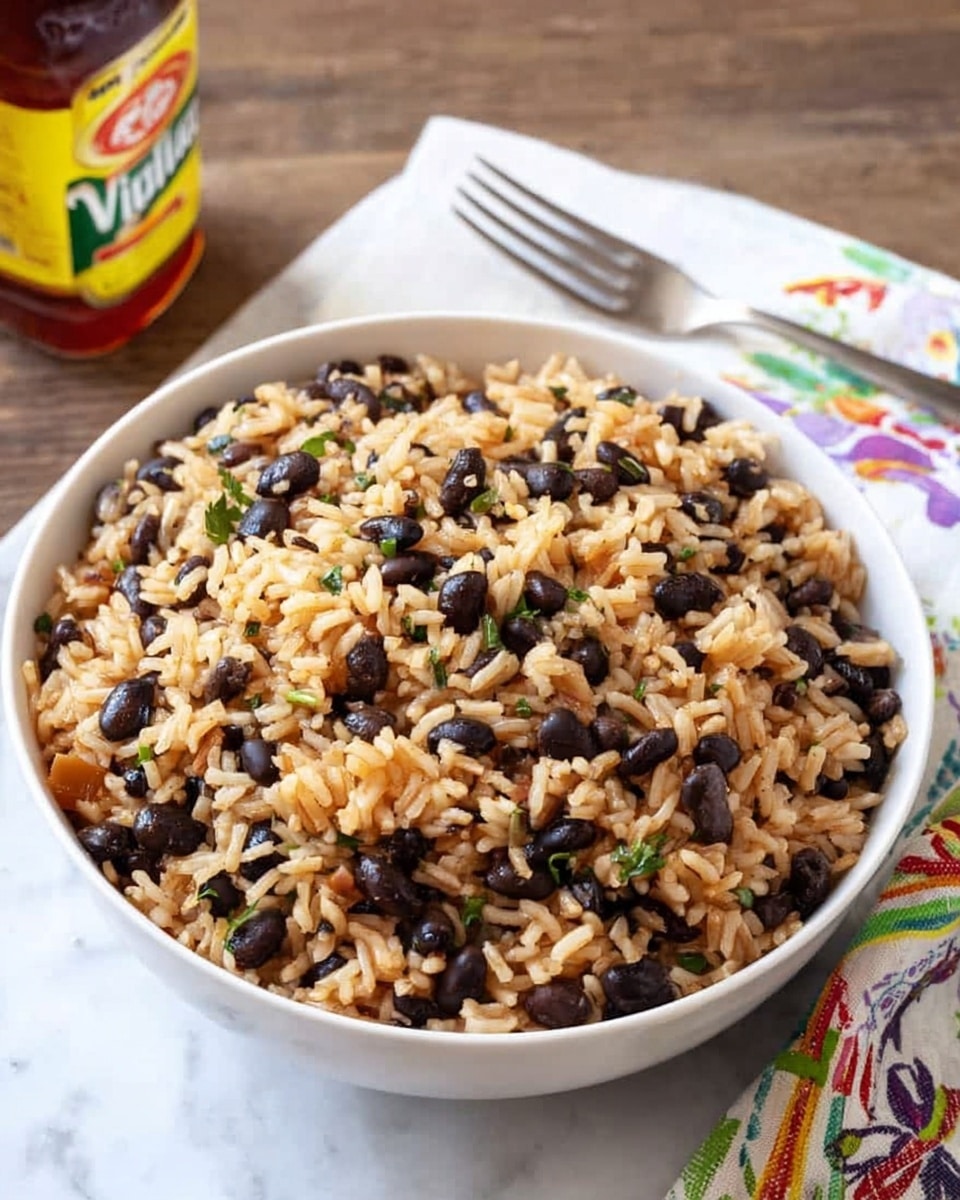 A white bowl filled with cooked rice mixed evenly with black beans and small green herbs. The rice has a light brown color, with some grains showing a slightly orange tint, and is mixed with whole black beans that add contrast. The herbs add small splashes of green throughout the dish. The bowl sits on a white marbled surface next to a metal fork resting on a white towel with colorful patterns, and behind it, there is a bottle with a yellow and red label. Photo taken with an iphone --ar 4:5 --v 7