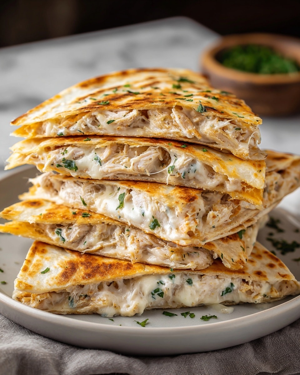 A stack of four triangular chicken quesadilla slices is shown on a white plate, each slice toasted to a golden brown with light grill marks. Each quesadilla features three layers—the top and bottom layers are thin, slightly crispy tortillas with a pale golden color, while the middle layer is filled with creamy white melted cheese mixed with shredded chicken and finely chopped green herbs. The cheese stretches slightly out of the edges, adding a melted, gooey texture. The quesadillas are stacked unevenly, showing the rich cheesy and chicken filling in soft layers. The plate is set on a light grey cloth with a blurred bowl of greenery in the background, all placed on a white marbled surface. Photo taken with an iphone --ar 4:5 --v 7